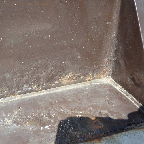 施工前、ポンプ制御盤のベース内側の入隅。溶接部に沿って錆が出て、塗膜の表面が荒れている状態