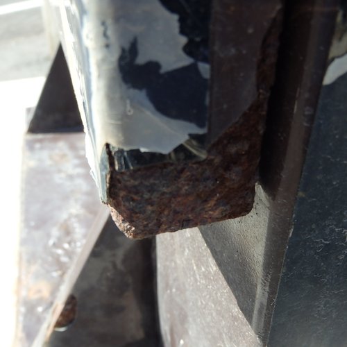 施工前、ポンプ制御盤の扉の下端。塗膜が層状にめくれ、端部の鋼板が厚く錆びている状態