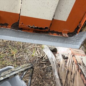 施工前、屋外キュービクルの扉の下端まわりで、オレンジ色の塗膜が錆で浮き上がっている部分